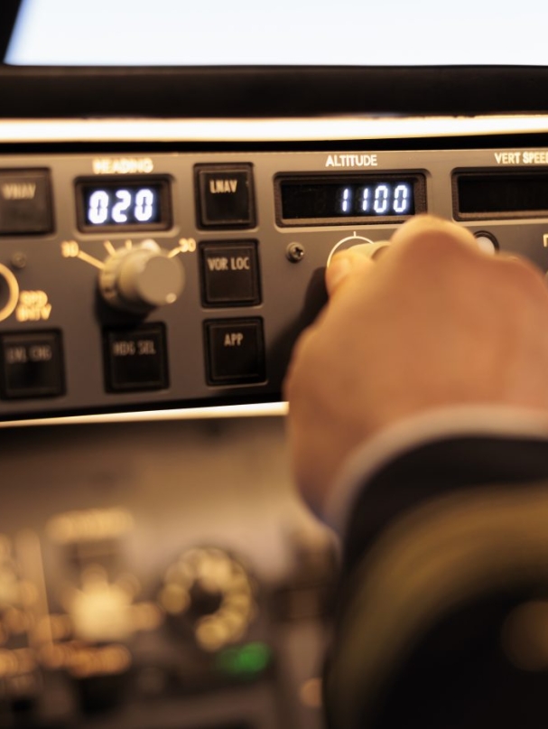 Captain pushing buttons to fix altitude level on control panel command, using navigation switch to fly airplane jet. Power radar with dashboard and handle to takeoff with plane. Close up.